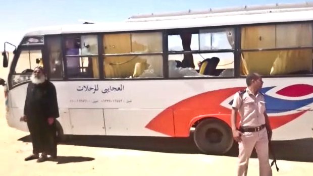 A policeman and a priest next to the bus at the centre of Friday's attack.