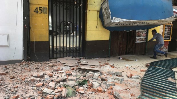 A man enters a damaged building after an earthquake in Mexico City.