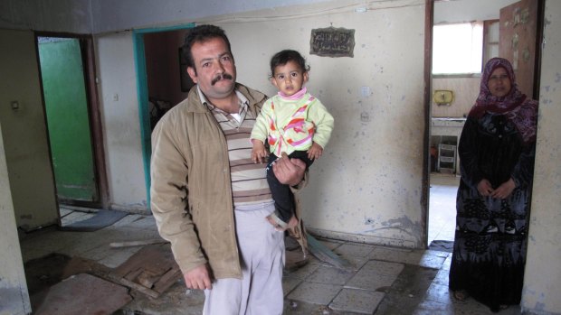 Life after the war: Fadel Nasser with family members inside their home in Gaza.