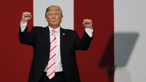 Stand up: President Donald Trump walks off the stage after speaking in Alabama.