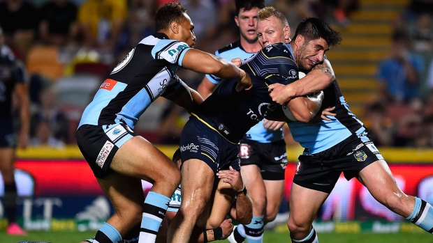 Going nowhere: James Tamou of the Cowboys is wrapped up by the Sharks' defence.