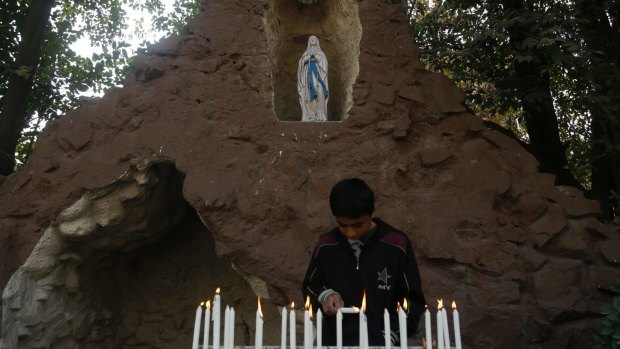 A boy lights candles at the Holy Family Catholic Church in Srinagar, Indian controlled Kashmir.
