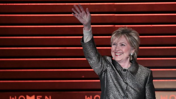 Hillary Clinton waves as she arrives onstage for an interview with Nicholas Kristof during the Women in the World Summit in New York.