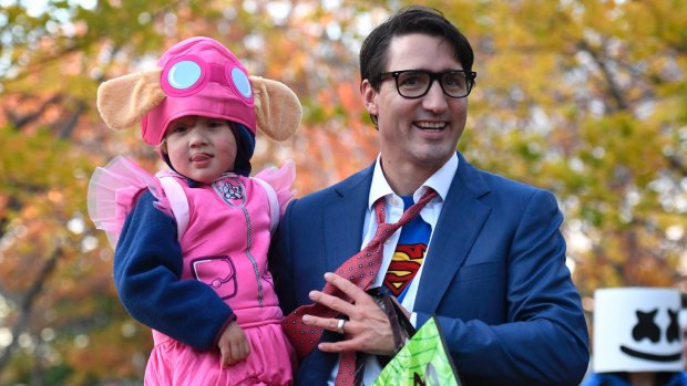 Justin Trudeau takes his youngest son Hadrien, dressed as Paw Patrol character Skye, trick-or-treating.