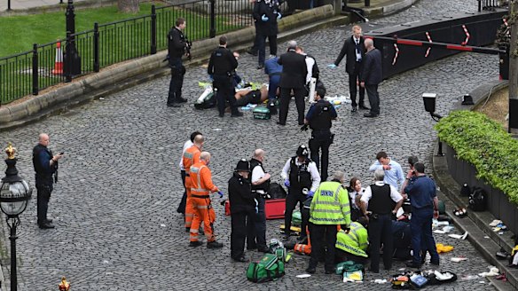Emergency services attend to injured people outside the Palace of Westminster, London, 