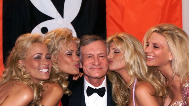 Playboy founder and editor in chief Hugh Hefner receives kisses from Playboy playmates during the 52nd Cannes Film Festival in 1999.