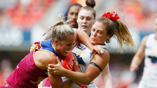 Kaitlyn Ashmore of the Lions is tackled by Georgia Bevan of the Crows.