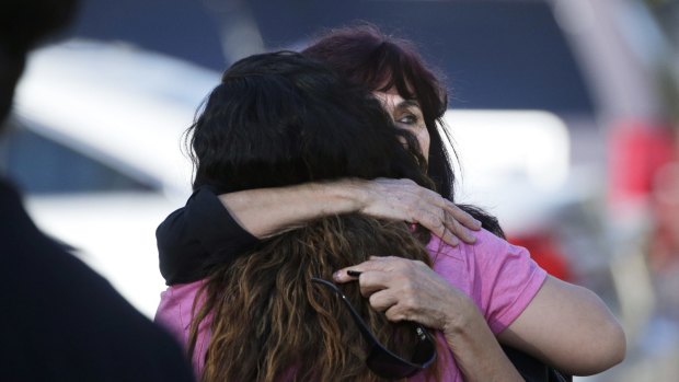 Teresa Hernandez, facing camera, is comforted by a woman as she arrives at the scene of the San Bernardino shooting.