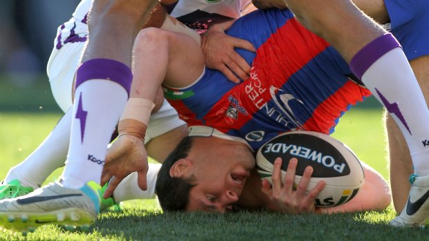 Duty of care: James McManus is tackled by the Storm at Hunter Stadium in 2013.