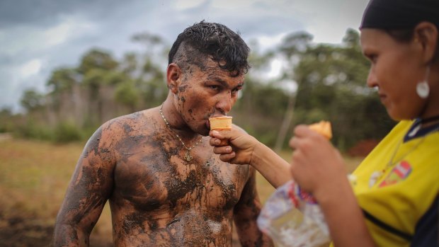 FARC rebel couple Camila gives her boyfriend Cristobal an ice cream as he plays soccer in the mud following a guerrilla conference in the remote Yari plains on Sunday.