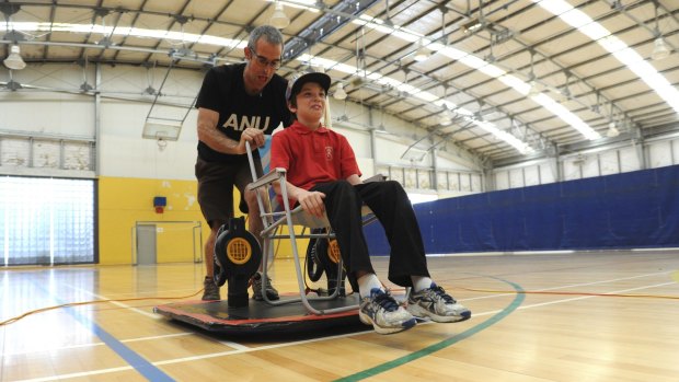 ANU science communicator Dr Graham Walker demonstrated a hoverboard at the ANU indoor sports centre. Henry Crane, 9, of
Weston gets a ride.
