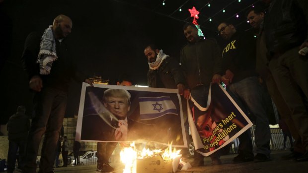Palestinian hold a poster of US President Donald Trump during a protest in Bethlehem, West Bank.