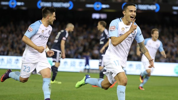 Cometh the hour: Tim Cahill races towards the corner flag for his trademark celebration after his wonder strike.