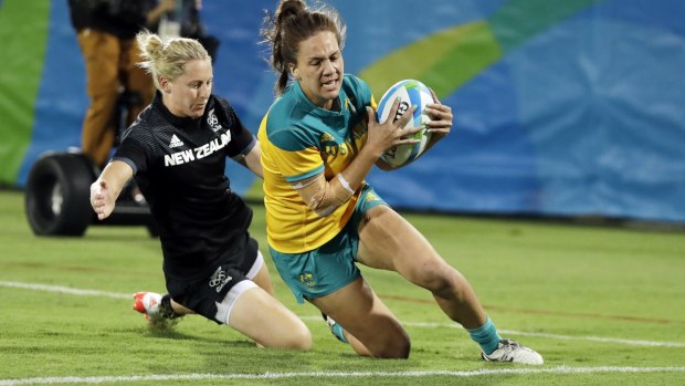 Australia's Evania Pelite scores a try as New Zealand's Kelly Brazier chases during the women's rugby sevens gold medal match at the Rio Olympics.