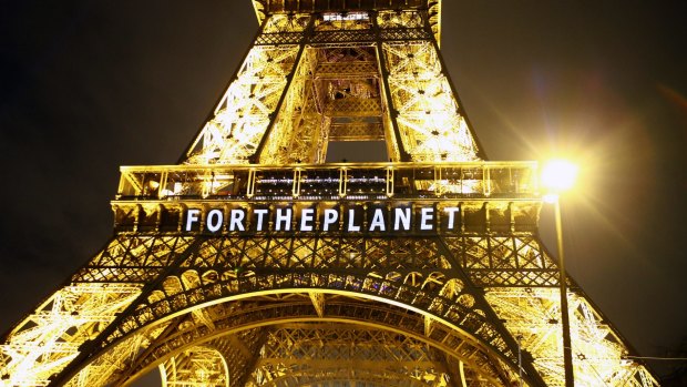 A slogan, "FOR THE PLANET", is projected on the Eiffel Tower as part of the UN Climate Conference in Paris.