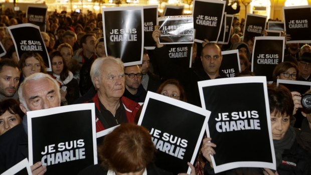People hold posters reading "I am Charlie" as they gather to express solidarity with those killed in an attack at the Paris offices of weekly newspaper <i>Charlie Hebdo</i>,