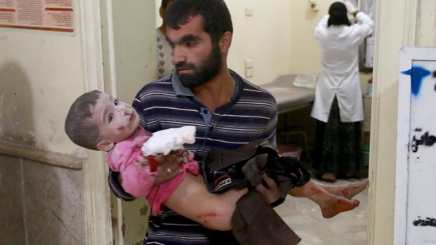 A Syrian man carries his son to a field hospital after Syrian and Russian army carried out airstrikes in Aleppo.