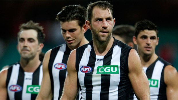 Outclassed: Dejected Magpies players trudge off the field.