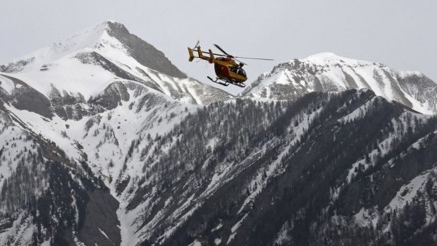 A rescue helicopter from the French Securite Civile flies over the French Alps following the crash of an Airbus A320.