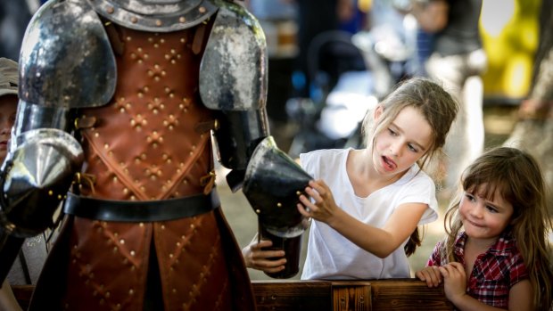 Emme, 8, and sister Georgie, 5, investigate a Sam Bloomfield sculpture The Lost Trades Fair at Kyneton Racecourse