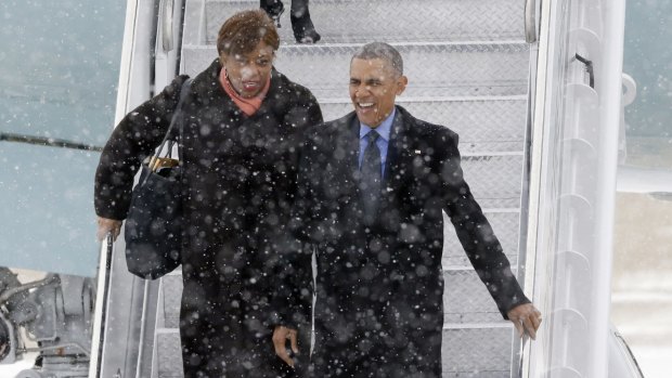 President Barack Obama, right, arrives in the snow on Air Force One at the Detroit Metropolitan Airport. His helicopter, Marine One, was cancelled when he arrived back in Washington, DC due to the snow.