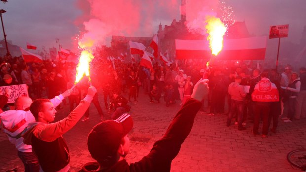 Several thousand right-wing nationalists wave Polish flags and burn flares as they march through Warsaw.