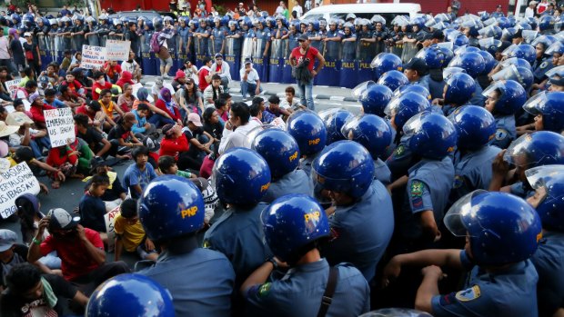 Riot police confine a group of protesters in Manila last year. 