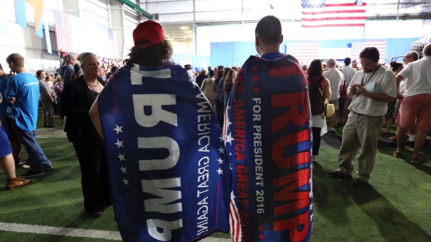 Two Trump supporters are pretty much ignored as they wear Donald trump capes at a campaign rally for Democratic presidential candidate Hillary Clinton  in Pennsylvania. 