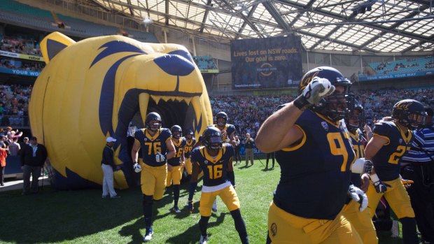Cal players run onto the field at Sydney's ANZ Stadium for the first game of American college football played in Australia.
