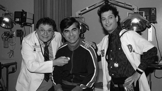 1984: Massachusetts Govenor Michael Dukakis, center, receives treatment from Stephen Furst, left, and Howie Mandel, stars of NBC's television series St. Elsewhere.