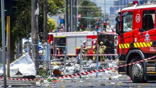 Firefighters survey the debris at the scene of the Footscray collision. 