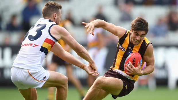 Falling Hawk: Kade Stewart of Hawthorn breaks free of a tackle by Brodie Smith.