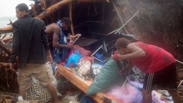 Residents look through the remains of a small shelter in Port Vila, the capital city of Vanuatu. 