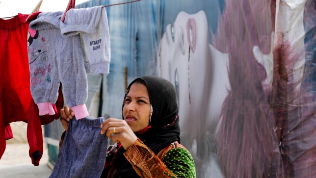 A Syrian hangs her laundry at an informal refugee camp in the Bekaa Valley town of al-Marj.