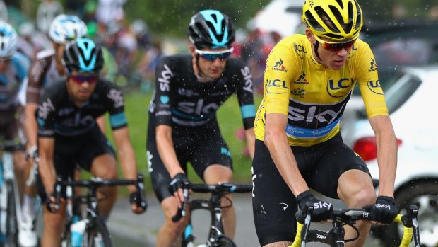 Chris Froome and Team Sky lead the pack as the rain pours.