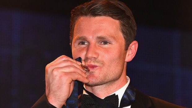 Patrick Dangerfield gives his Brownlow Medal a kiss.