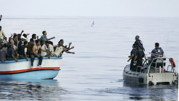 Armed Forces of Malta marines toss bottles of water to a group of about 180 asylum seekers south-west of Malta.