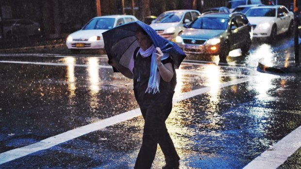 A woman battles a soggy morning commute in Darlinghurst on Tuesday.