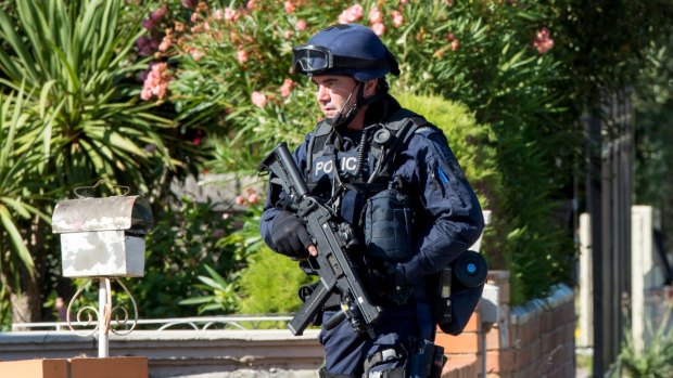 An armed officer outside the house in Lavenia street St. Albans.