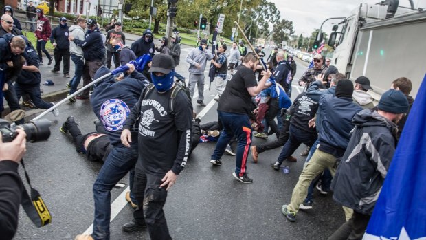 Protesters from rival groups, many wearing masks or balaclavas, fight each other in Coburg.