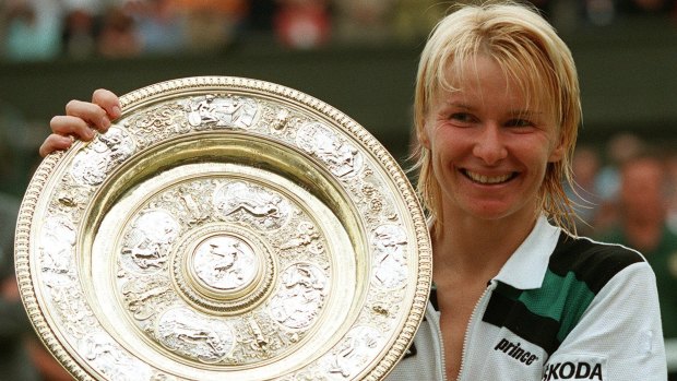 Jana Novotna displays the Wimbledon women's singles trophy after her victory over France's Nathalie Tauziat in the 1998 final.