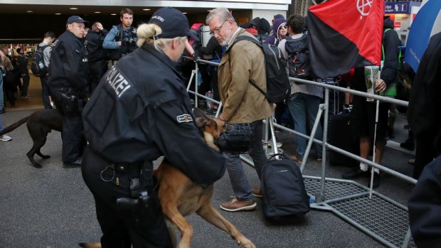 Police monitor protesters who have arrived in Hamburg to rally against the G20.