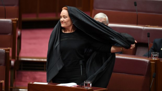 One Nation senator Pauline Hanson takes off the burqa. The stunt would likely not have been allowed under old Senate rules.