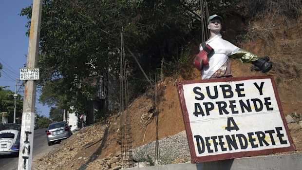 A sign advertising a boxing school with a message that reads in Spanish: "Come on up and learn to defend yourself", in Acapulco, Mexico.