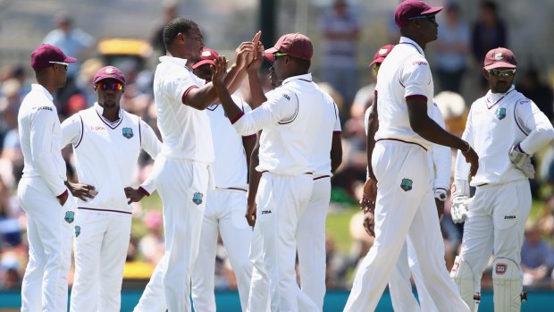The West Indies celebrate dismissing Joe Burns, a rare wicket on day one in Hobart.