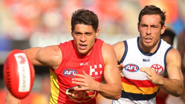 Dion Prestia of the Suns and Crow Richard Douglas compete for the ball.
