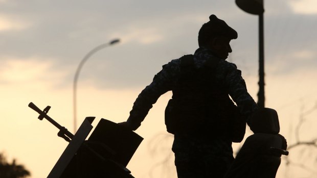 An Iraqi policeman stands guard the provincial council building in Basra, Iraq.