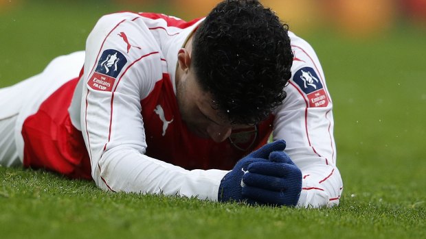 Arsenal's Alex Oxlade-Chamberlain lies on the pitch after losing to Hull City.