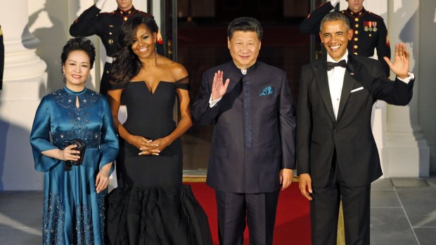 US President Barack Obama, right, and Chinese President Xi Jinping wave along with, wives Peng Liyuan and first lady Michelle Obama as they arrive for a state dinner at the White House.