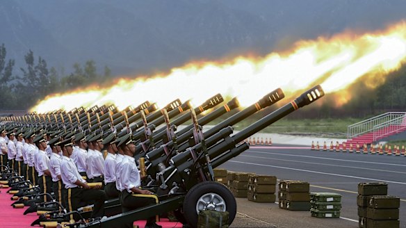 Paramilitary policemen and gun salute team members fire cannons at an unrelated event in Beijing.